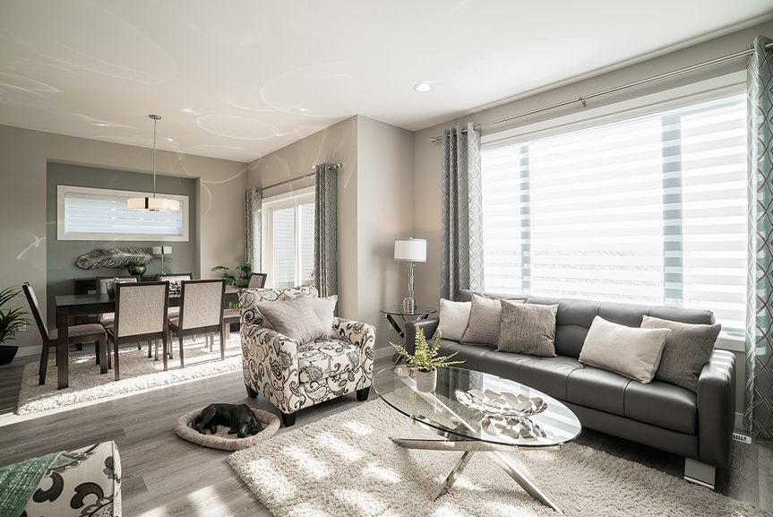 great room and eating area with beige painted walls, vinyl plank flooring and white painted ceilings broadview homes winnipeg the preston