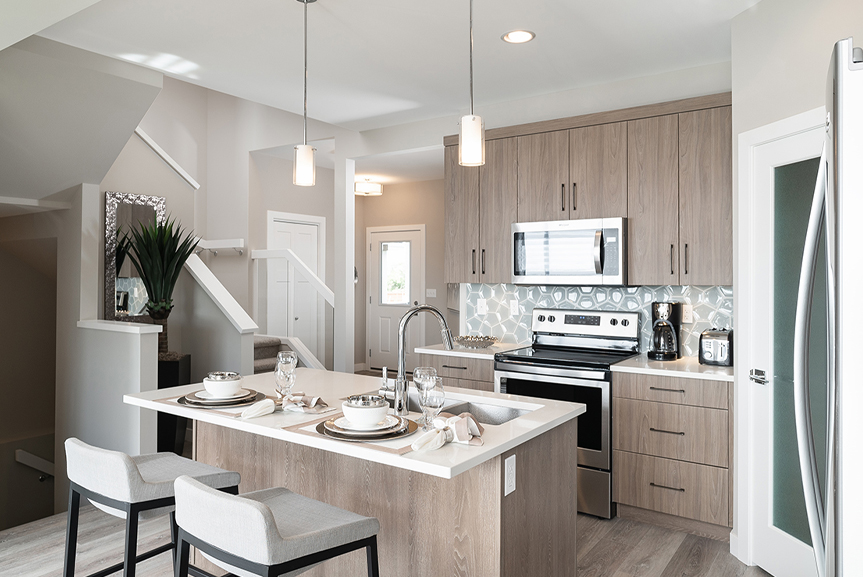 kitchen with soho woodgrain flint cabinets, blue ceramic tile backsplash, island and walk-in pantry the preston broadview homes winnipeg