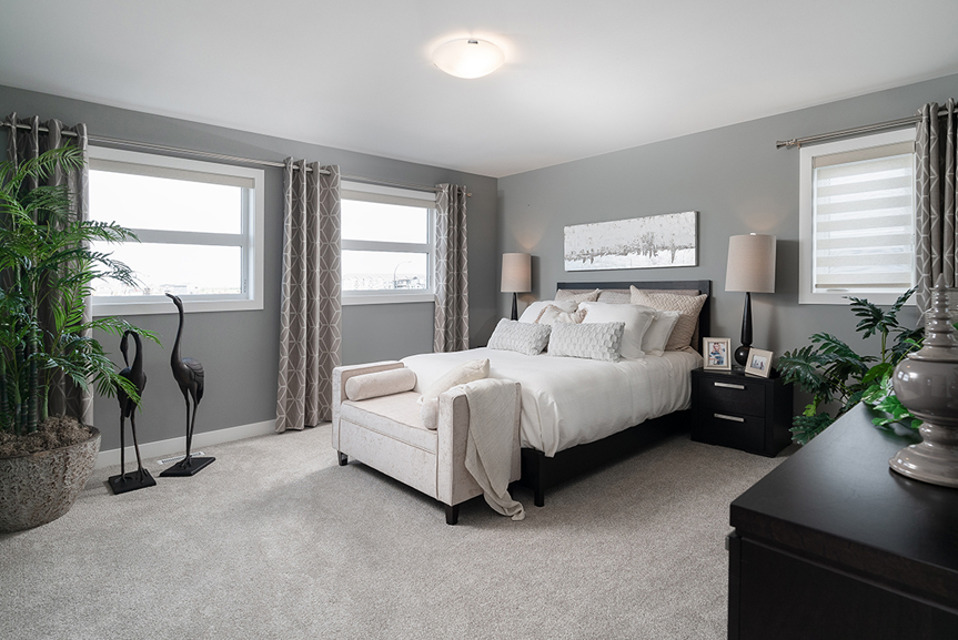 master bedroom with green walls, white casing and baseboards, two picture windows and a casement window the preston broadview homes winnipeg